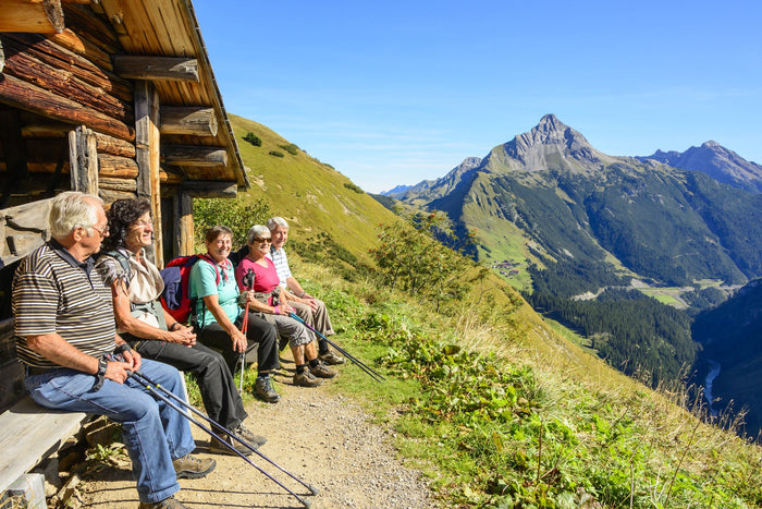 Senioren beim Wandern in den BergenLaptop und hält eine Nahrungsergänzungsmitteldose in der Hand.